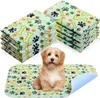 A puppy sits on a dog pee pad with stacks of similar pads in the background. Produktbild-Vorschau