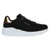 A side view of a black Skechers sneaker with a white sole and gold accents. Voir les images du produit