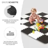 A baby playing on a black and white foam puzzle mat with building blocks. Náhled obrázku produktu