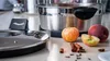 A close-up shot of a Remoska electric pot with apples, a peach, and spices on a countertop. Anteprima dell’immagine prodotto