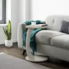 A side table next to a sofa in a living room. Voir les images du produit