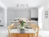 A dining room with a kitchen in the background, set for a meal. Podgląd zdjęcia produktu