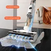 A close-up view of a cordless wet dry vacuum cleaner cleaning a spill on a dark tiled floor, with diagrams indicating clean and dirty water tanks. Produktbild-Vorschau
