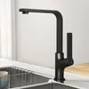 A black kitchen faucet is shown in a modern kitchen setting, positioned over a stainless steel sink. Produktbild-Vorschau
