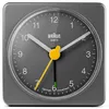 A close-up, front-facing view of a gray Braun analog alarm clock. Produktbild-Vorschau