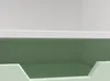 A close-up view of the top section of a mint green and white storage bench. Podgląd zdjęcia produktu