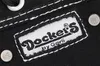 A close-up view of a label on a black fabric product, likely a shoe or bag. Produktbild-Vorschau
