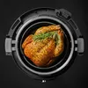 A roasted chicken with herbs inside an air fryer. Produktbild-Vorschau