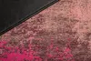 A close-up view of a textured fabric with an abstract pattern in shades of pink and burgundy, next to a black material. Produktbild-Vorschau