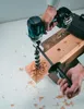 A person is using a cordless drill to bore a hole in a piece of wood. Produktbild-Vorschau