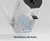 Close-up view of the back of a white security camera, showing the SD card slot with a 128GB card inserted, and a flip-open cover revealing USB and Reset ports. Produktbild-Vorschau