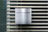 A modern mailbox mounted on a slatted wooden fence. Anteprima dell’immagine prodotto