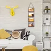 A living room scene with a couch, pillows, and wall decor. Produktbild-Vorschau