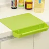 A green cutting board with a built-in tray is placed on a kitchen counter. Anteprima dell’immagine prodotto