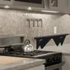 A black stove gap cover is shown in a kitchen setting, placed on a stove. Anteprima dell’immagine prodotto
