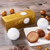Lindt Golf Balls chocolates and hazelnuts arranged on a wooden surface. Podgląd zdjęcia produktu