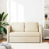 A cream-colored sofa with a sleeping function is shown in a well-lit room with a plant and a bookshelf. Produktbild-Vorschau