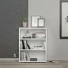 A white bookshelf with books and decorative items on it, placed against a patterned wallpaper and a plain wall. Produktbild-Vorschau