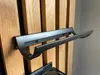 A close-up shot of a black metal wine rack mounted on a wooden slatted wall. Produktbild-Vorschau