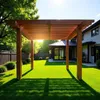 A backyard scene with a wooden pergola casting shadows on a green lawn, with a modern house in the background. Produktbild-Vorschau