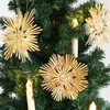 Close-up of straw star ornaments hanging on a Christmas tree with decorative lights. Produktbild-Vorschau