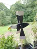 A wooden eagle wind spinner is displayed outdoors, with greenery and trees in the background. Podgląd zdjęcia produktu