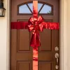 A large red bow is attached to a brown wooden door, making it look like a gift. Náhled obrázku produktu