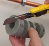 A hand is holding a piece of pipe insulation while a utility knife is cutting it. Produktbild-Vorschau