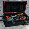 An open tool box filled with various tools, sitting on a concrete surface. Náhled obrázku produktu