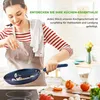 A woman is cooking in a kitchen, adding ingredients to a frying pan. Anteprima dell’immagine prodotto