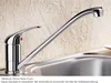 A chrome kitchen faucet is shown in a sink against a textured wall. Produktbild-Vorschau