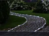 A garden path illuminated by a solar LED light string. Produktbild-Vorschau
