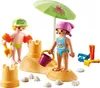 Two children playing with a sandcastle on the beach. Anteprima dell’immagine prodotto
