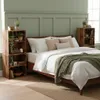 A bedroom scene with a bed, nightstands made of crates, and green walls. Produktbild-Vorschau