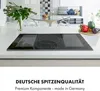 A modern kitchen counter with an induction cooktop and vegetables on a cutting board. The background shows a living area. Produktbild-Vorschau
