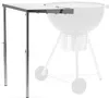 A stainless steel side table is shown next to a charcoal grill. Náhled obrázku produktu