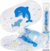 A bath mat with a dolphin design is shown, along with a rolled-up mat and its packaging. Produktbild-Vorschau