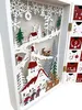A close-up, angled view of an open wooden advent calendar with a festive Christmas village scene inside. The calendar has small drawers on the right side. Produktbild-Vorschau
