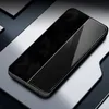 A black smartphone case with a diagonal split between a textured black surface and a reflective black surface, placed on a multi-layered gray surface. Náhľad obrázku produktu