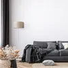 A living room scene with a sofa, a floor lamp, and decorative elements. Produktbild-Vorschau