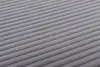 Close-up view of a grey corduroy fabric with parallel ridges. Voir les images du produit