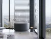 A modern bathroom with a large window overlooking a scenic landscape, featuring a freestanding bathtub and a small trash can. Produktbild-Vorschau