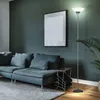 A modern living room with a sofa, floor lamp, and a framed picture on the wall. Produktbild-Vorschau