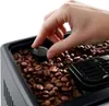A hand is adjusting a dial on a coffee bean hopper of a coffee machine. Produktbild-Vorschau