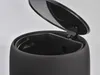A close-up view of the top of a black trash can with the lid open. Produktbild-Vorschau