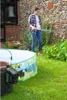 A woman is watering plants in a garden next to an inflatable pool. Náhľad obrázku produktu