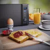 A breakfast scene with a toaster, toast, jam, egg, orange juice, and coffee. Anteprima dell’immagine prodotto