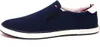 A side view of a navy blue slip-on sneaker with a white sole. Náhled obrázku produktu