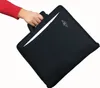 A hand holding a black folder with a white interior. Náhľad obrázku produktu