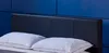 A close-up view of a bed with a black headboard and two white pillows. Produktbild-Vorschau